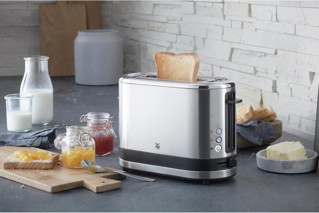 WMF KÜCHENminis 1-Scheiben-Toaster Langschlitz XXl-Toast Brötchenaufsatz 7 Bräunungsstufen Überhitzungsschutz 600W Edelstahl matt - Imagen del moderno tostador de acero inoxidable mate con tecnología avanzada y funciones prácticas para un tostado perfecto.